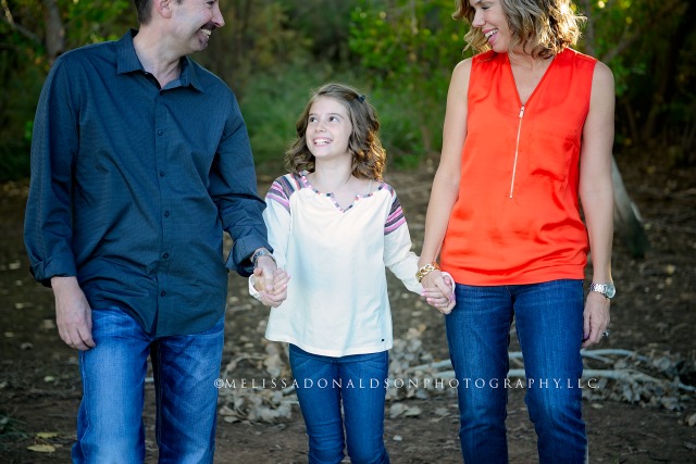 family walking and holding hands in forest in Gilbert
