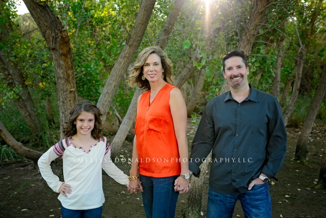 family with sunburst in forest holding hands in Gilbert, AZ