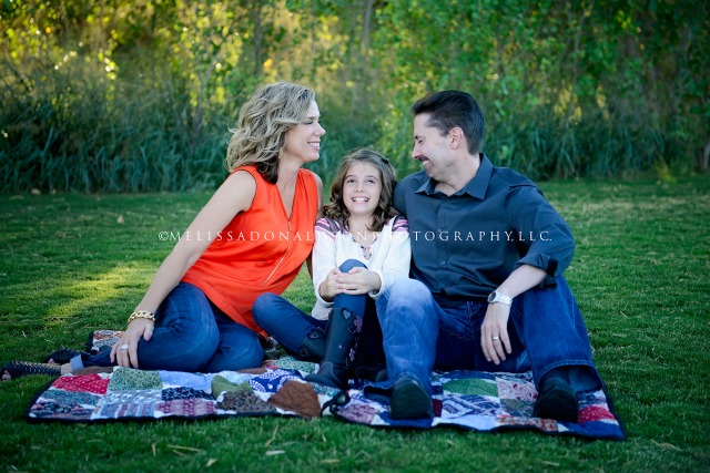 family laughing on a blanket