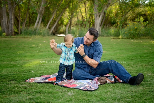 dad and son playing on a blanket 