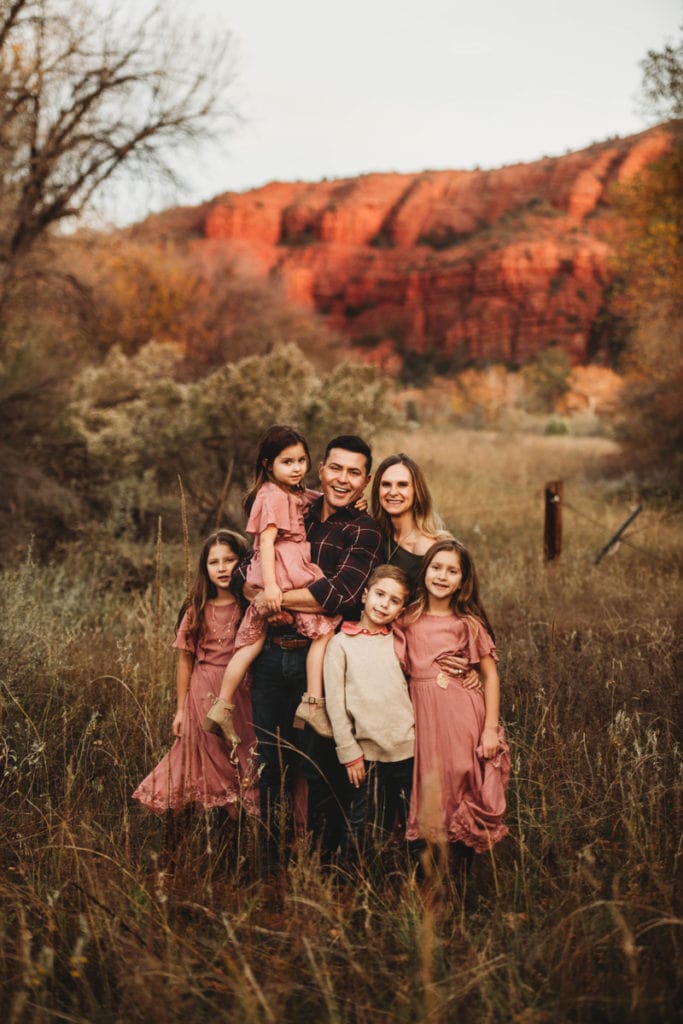 Family Photographer, a family of 6 huddles together in the outdoors