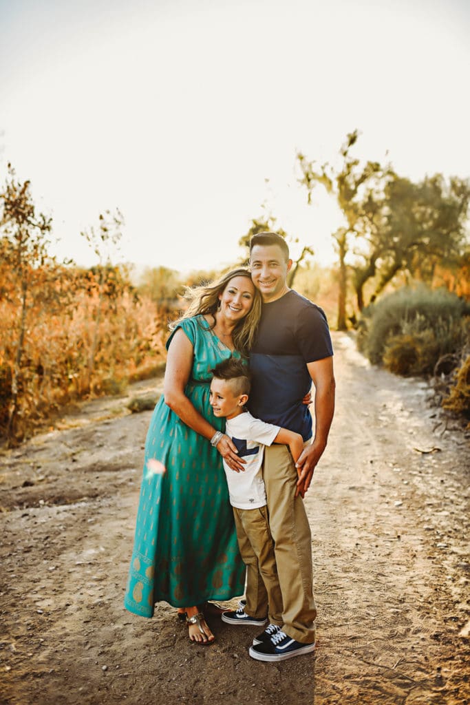 Family Photographer, a young mother and father stand with their son on a country trail